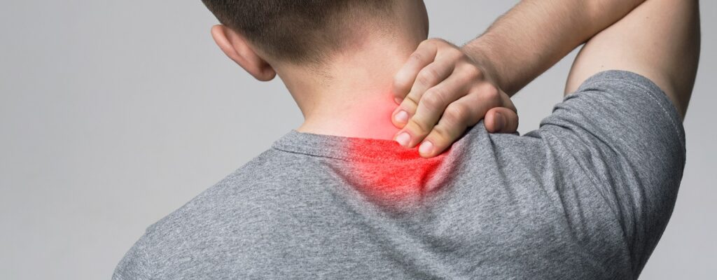 Young man massaging his sore neck, back view